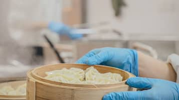 A person wearing blue gloves handling a wooden container with a label.