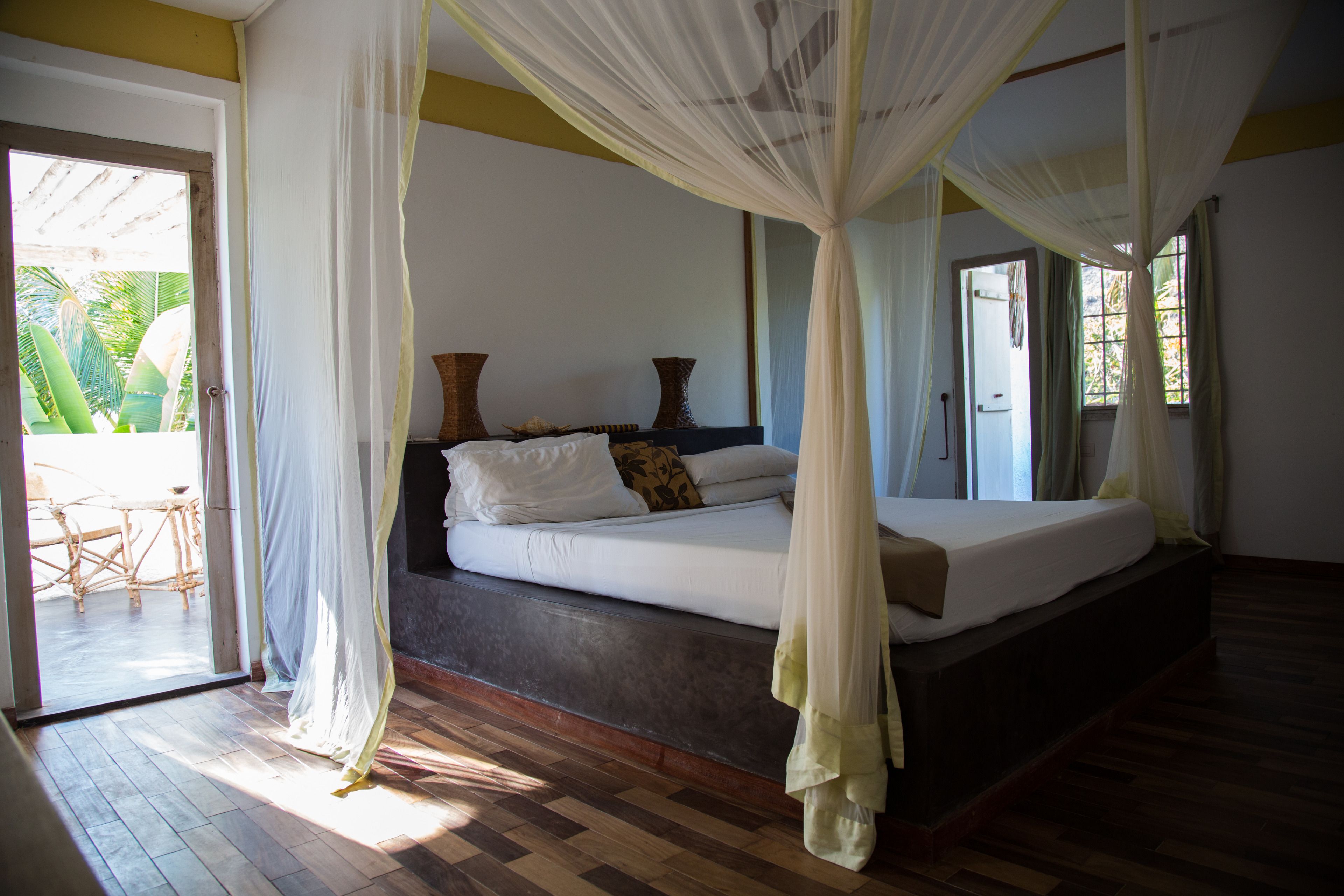 Un dormitorio con cama, dosel y vistas al exterior.