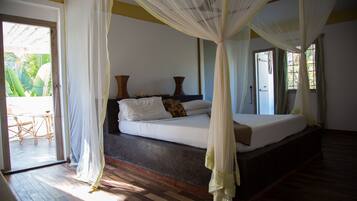 Un dormitorio con cama, dosel y vistas al exterior.