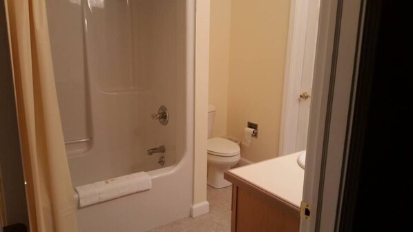 A bathroom with a shower, toilet, and sink.