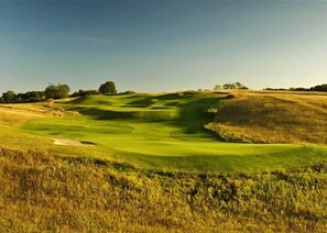 A golf course with rolling green hills and a clear sky. - Dunmaglas Golf Course (Charlevoix)