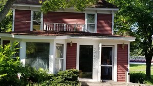 A two-story house with a porch, large windows, and a sign that reads "Dunnmaglas Golf Course." - Dunmaglas Golf Course (Charlevoix)