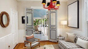 Un salón con sofá, sillón, mesa de centro y vistas al exterior.