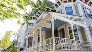 A historic building with a prominent balcony and a sign reading "21 BROAD HOTEL". - 21 Broad Hotel (Nantucket)