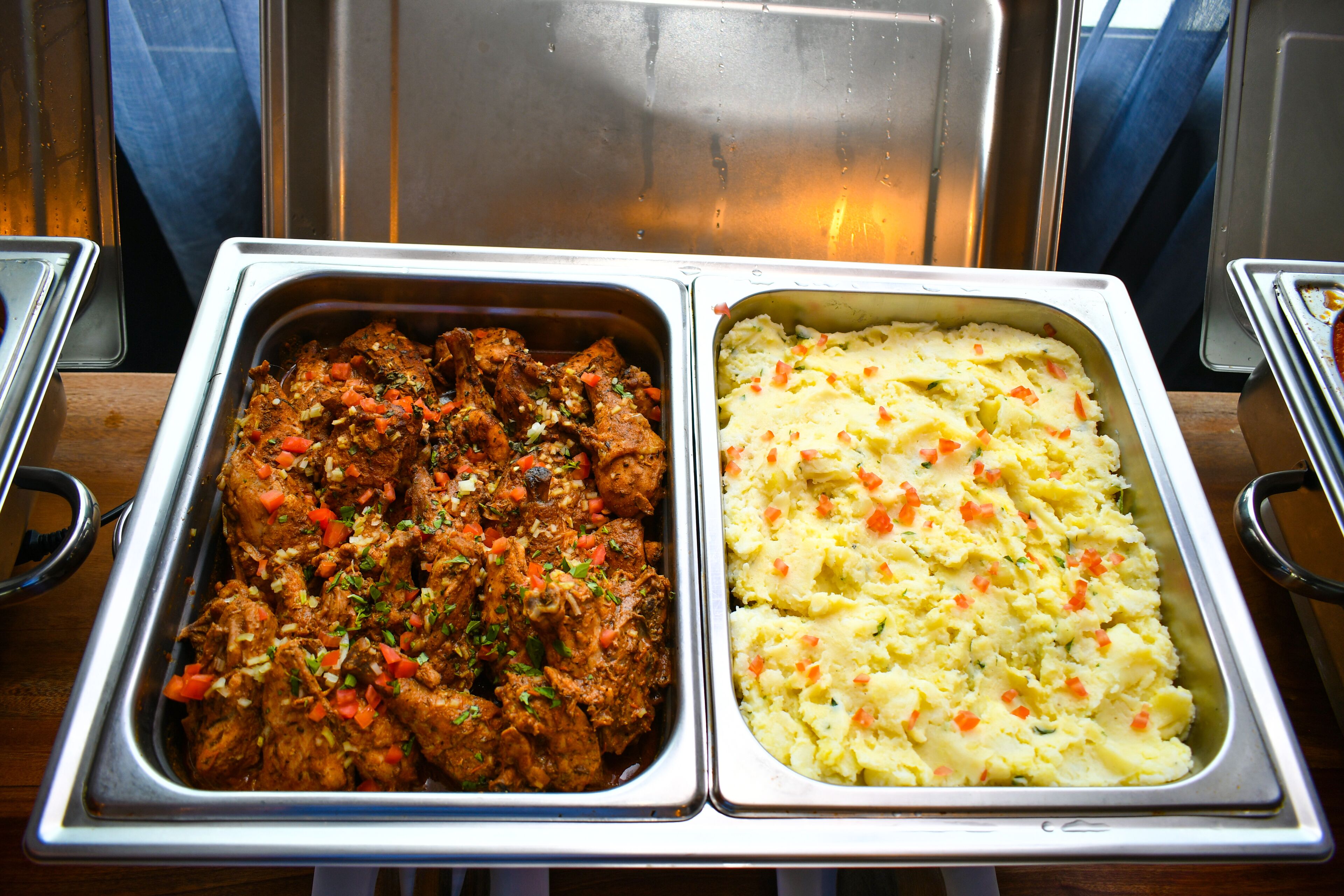 Ein Buffet mit zwei Schüsseln Essen: eine mit einem Fleischgericht und die andere mit Kartoffelpüree.