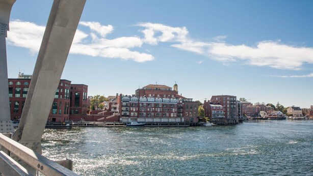 A view of a river with buildings along the shore, a bridge in the foreground, and a clear sky. - The Bow Hotel (Portsmouth)