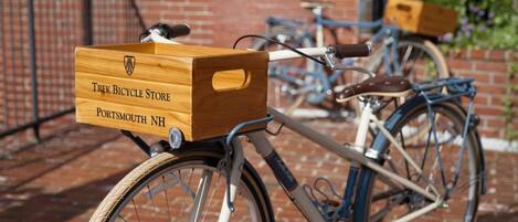 Un vélo muni d’une boîte en bois portant l’inscription « Trek Bicycle Store Portsmouth NH » et fixée à l’avant.