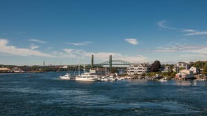 A harbor with boats docked, a bridge in the background, and buildings along the waterfront. - The Bow Hotel (Portsmouth)