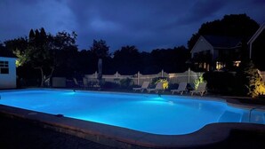 A swimming pool with a wooden deck and lounge chairs. - Brandon Inn (Brandon)