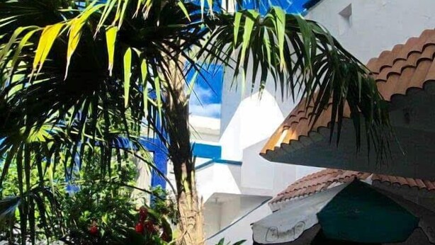 Un edificio con fachada blanca y techo verde.