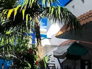 A building with a white facade and a green roof. - Alicia's Bed & Breakfast (Cozumel)