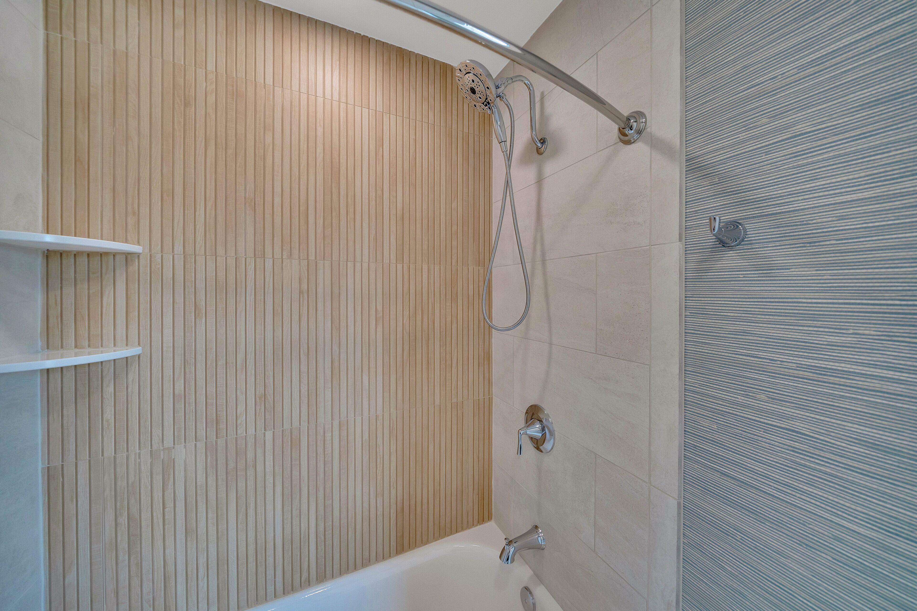 Ein modernes Badezimmer mit einer Wand aus Holzpaneelen, einer Badewanne und einer Duschkabine.
