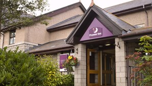 Un edificio con un cartello che indica 'Premier Inn' e un'ampia porta d'ingresso.