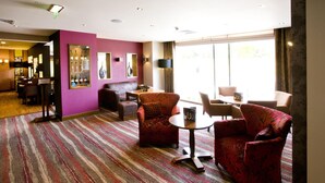 A hotel lobby with a striped carpet, a bar area, and seating arrangements. - Premier Inn Aberdeen Airport - Dyce (Aberdeen)