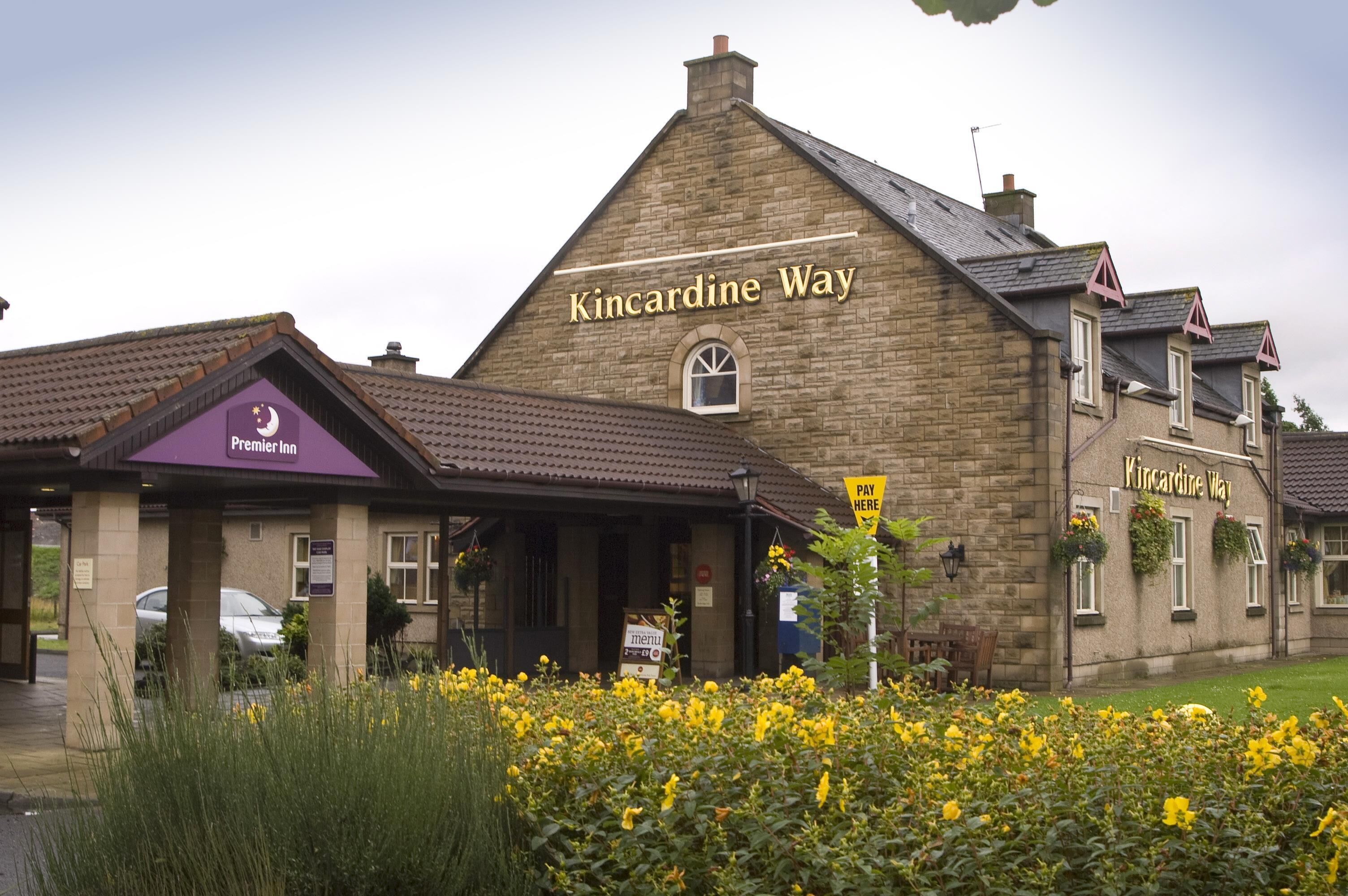 A stone building with a sign reading 'Kincardine Way' and a 'Premier Inn' sign on the left.