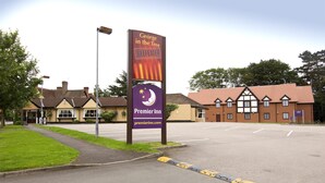 L’entrée d’un hôtel, avec une enseigne lumineuse indiquant « George in the Tree BeefEater » et une enseigne Premier Inn.