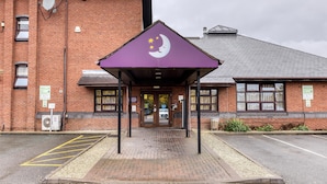 A building with a purple awning, a brick facade, and a sign with a crescent moon and stars. - Premier Inn Birmingham City - Aston (Birmingham)