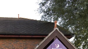 Ein Gebäude aus Ziegelsteinen mit einem braunen Dach und einem Schild für Premier Inn.