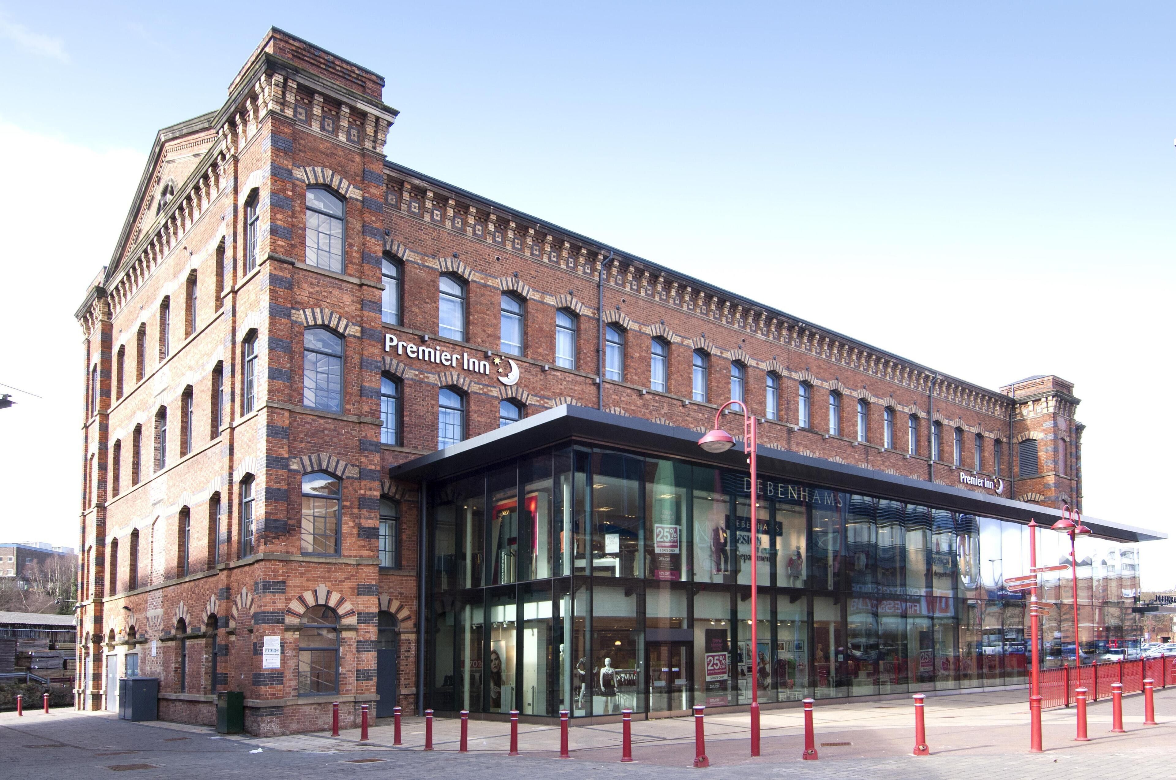 A brick building with a glass entrance and signage for Premier Inn.