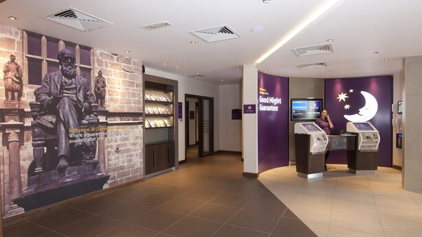 A hotel lobby with a statue, a reception desk, and a sign for a 'Good Night Guarantee.' - Premier Inn Shrewsbury Town Centre (Shrewsbury)