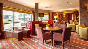 A hotel lobby with seating areas, a fireplace, and large windows. - Premier Inn Worcester City Centre (Worcester)