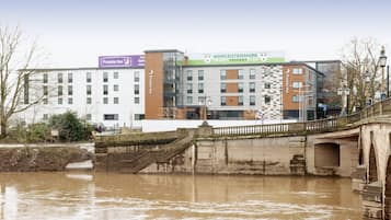 Experience the Premier Inn's contemporary design, featuring a mix of glass and brick facades, and a historic stone bridge.