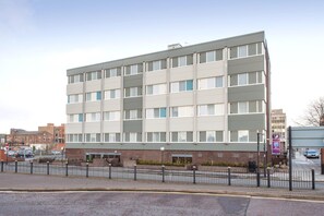A multi-story building with a flat facade, large windows, and a parking sign indicating a parking area. - Premier Inn Birkenhead Town Centre (Birkenhead)