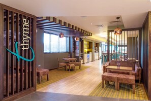 A restaurant interior with wooden furniture, a staircase, and a sign reading 'thymine'. - Premier Inn Birkenhead Town Centre (Birkenhead)