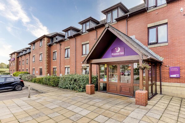 A brick building with a purple awning labeled 'Premier Inn.' - Premier Inn Blackpool East - M55 J4 (Blackpool)