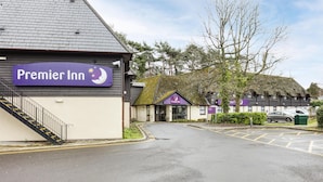 A building with a sign reading 'Premier Inn' and a staircase leading to the entrance. - Premier Inn Bournemouth/Ferndown (Ferndown)