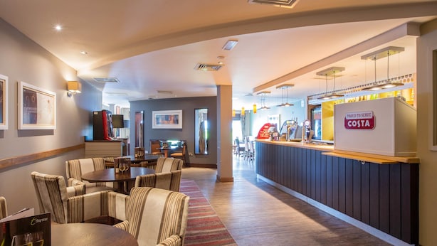 A hotel lobby with a dining area, a reception desk, and a bar. - Premier Inn Bournemouth Westbourne (Bournemouth)