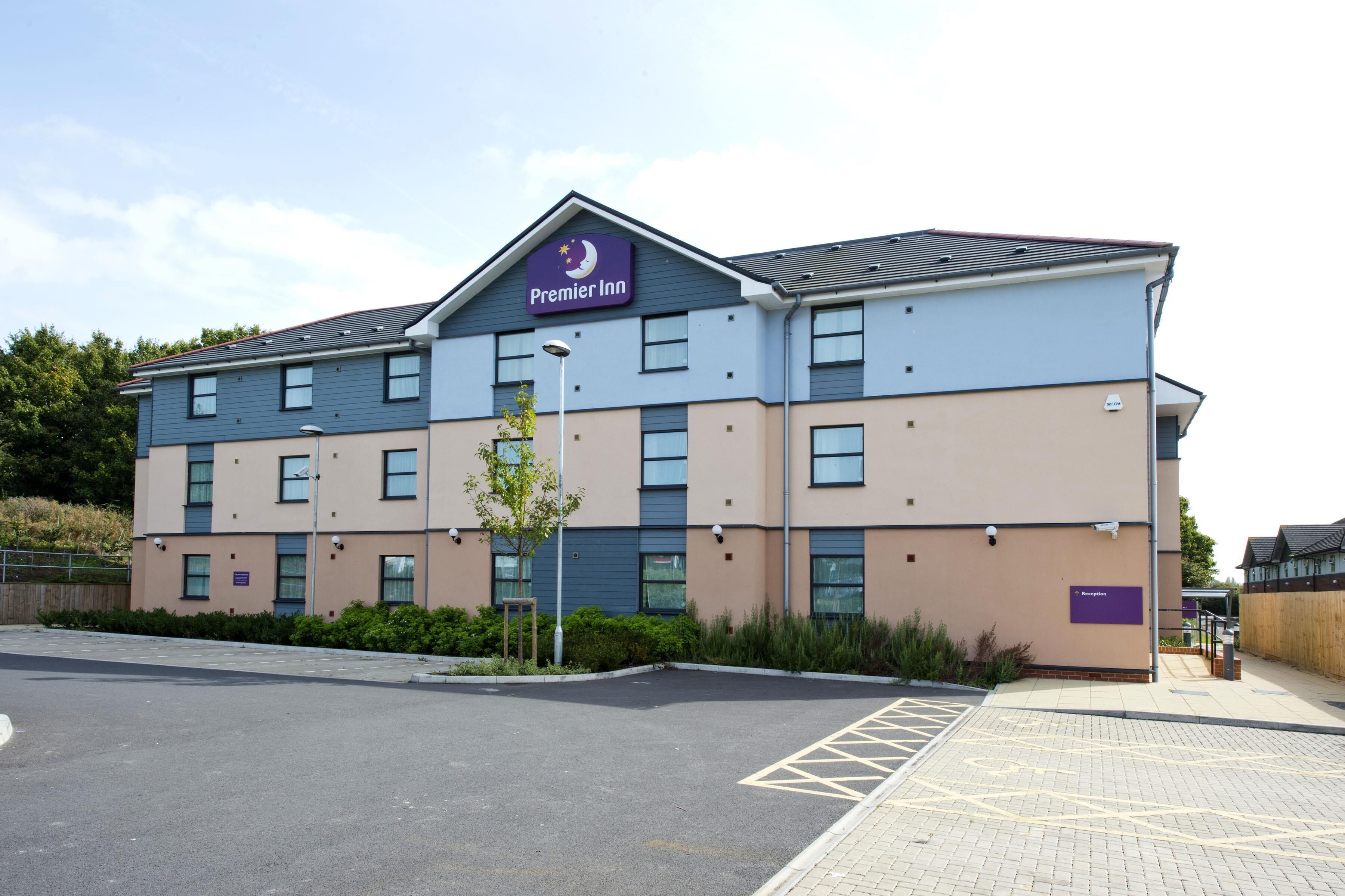 Een Premier Inn hotel met een modern design, herkenbaar aan een plat dak, veel ramen en een receptie.