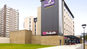 A Premier Inn hotel with a prominent sign, a nearby Beeffeater restaurant, and a modern building in the background. - Premier Inn Halifax Town Centre (Halifax)