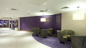 A hotel lobby with a starry wall, a reception desk, and seating areas. - Premier Inn Halifax Town Centre (Halifax)