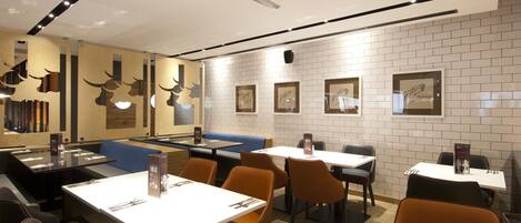 A restaurant with tables, chairs, and a counter.