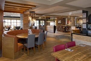 Un restaurante con interior de madera, asientos de cuero y una zona de bar.