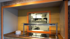 A kitchen area with stainless steel appliances, a glass enclosure, and a wooden countertop. - Premier Inn Frome (Frome)