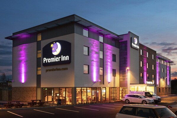 A Premier Inn hotel with a modern design, large windows, and a parking lot.