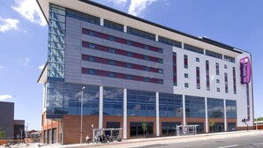 Un hôtel moderne doté d’une façade en verre, de plusieurs étages et d’un logo Premier Inn bien visible.