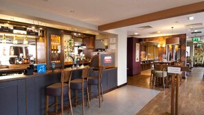 Un espace bar avec des tabourets, une enseigne Costa et un panneau indiquant que le bar est réservé aux clients.