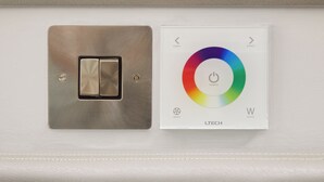 En väggmonterad strömbrytare och en kontrollpanel för färgtemperatur.