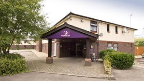A hotel entrance with a marquee sign, a brick facade, and a paved driveway. - Premier Inn Caerphilly - Corbetts Lane (Caerphilly)