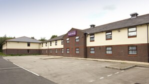 A hotel with a sign reading 'Premier Inn,' featuring a brick facade, multiple windows, and a parking lot. - Premier Inn Caerphilly - Corbetts Lane (Caerphilly)
