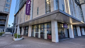 Ingresso moderno di un hotel con un'insegna Premier Inn ben visibile, ampie vetrate e un'area d'ingresso coperta.