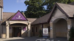 A hotel entrance with a purple sign for Premier Inn, an archway, and a sign for Weavers Mill. - Premier Inn Dundee North (Dundee)