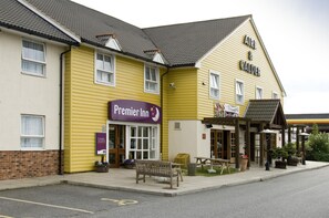 A yellow building with a 'Premier Inn' sign, a bench, and outdoor seating. - Premier Inn Goole (Goole)