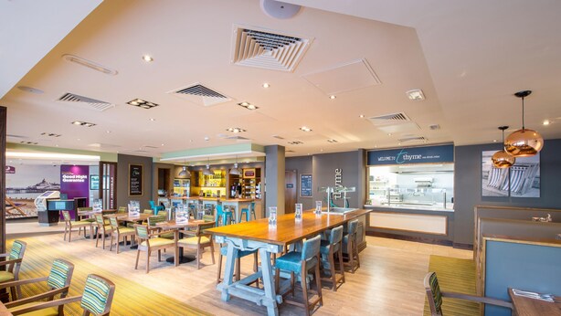A modern hotel lobby with a bar area, seating arrangements, and a reception desk. - Premier Inn Eastbourne Town Centre (Eastbourne)