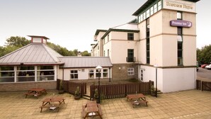 Un hôtel avec une enseigne indiquant « Premier Inn » et un bâtiment séparé portant l’inscription « Brewers Fayre ».