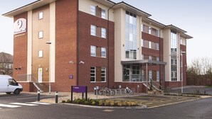 A two-story building with a reception area, a staircase, and a parking lot with bicycles. - Premier Inn Burton On Trent Central (Burton on Trent)