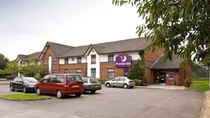 A hotel with a parking lot, a red van, and a car parked in front. - Premier Inn Taunton East (Taunton)
